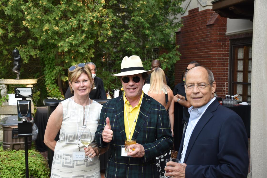 Photograph of three people outside Cranbrook House for an event