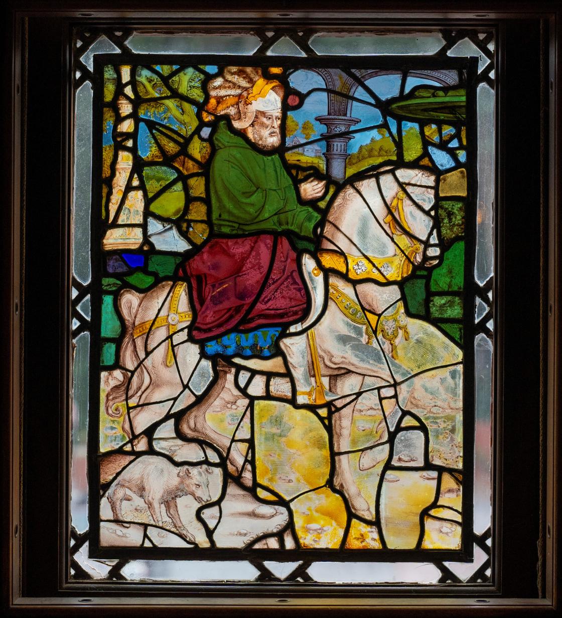 Photograph of a stained-glass window featuring a man riding a horse