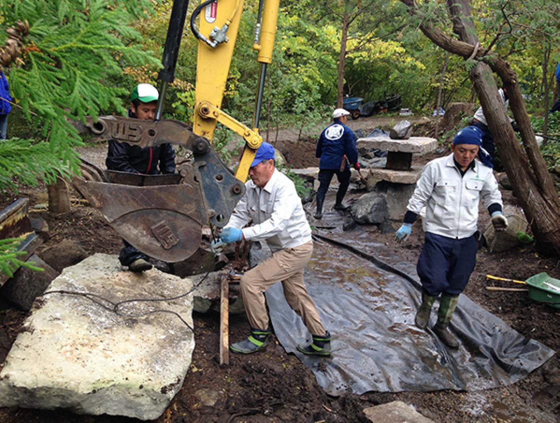 Hiromu Terashita (center) Prepares a Stone Slab for Placement in the Lily Pond Cascade with Yasumasa Imada (right), October 5, 2018. Photography by Gregory Wittkopp.