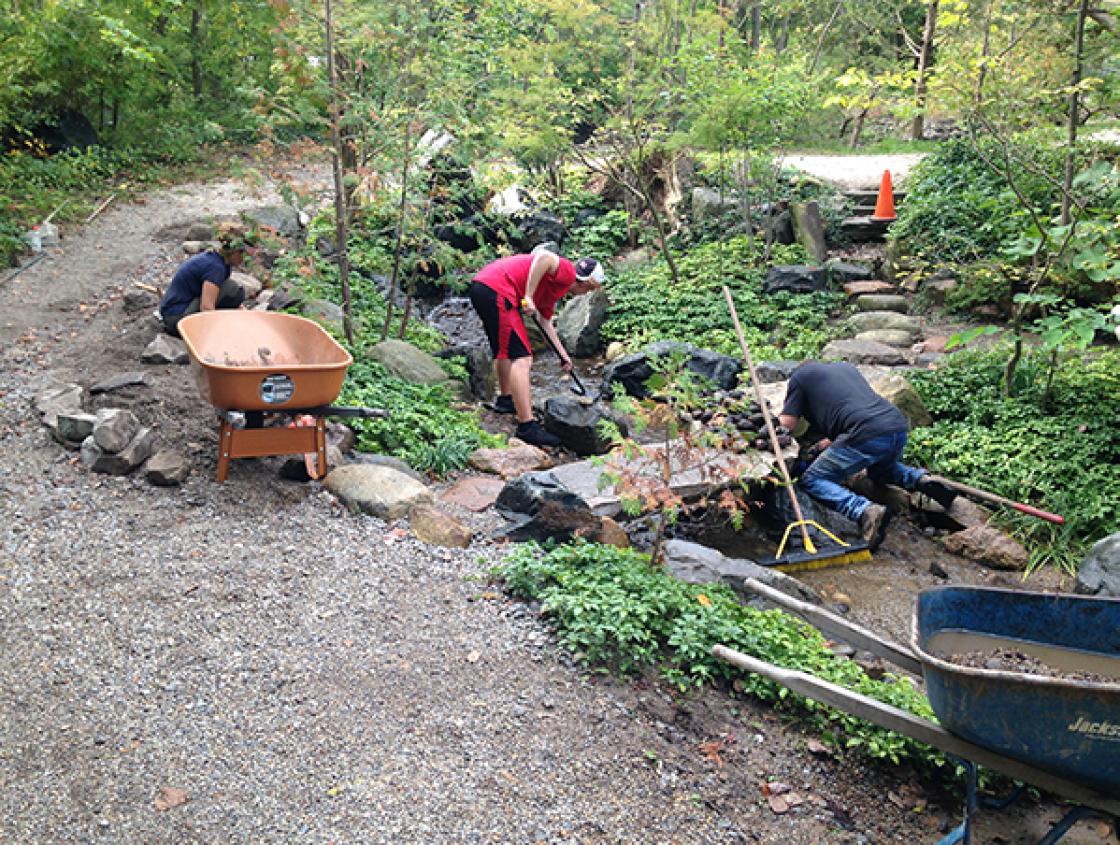 Emily Fronckowiak (far left) Set Stones Along the Edge of the Lily Pond Cascade and Remove Debris from the Stream Bed, October 1, 2019.  Photography by Gregory Wittkopp.